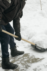 Person shoveling heavy snow with poor posture.