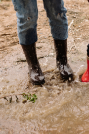 person walking carefully on muddy ground during spring mud season