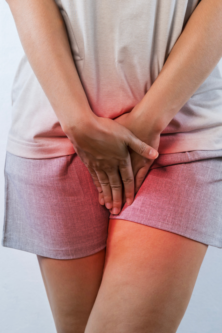 Woman standing at work holding her lower abdomen due to pelvic pressure after standing all day