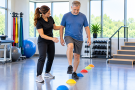 Patient practicing coordinated stepping and balance exercises with a physical therapist during ataxic cerebral palsy physical therapy.